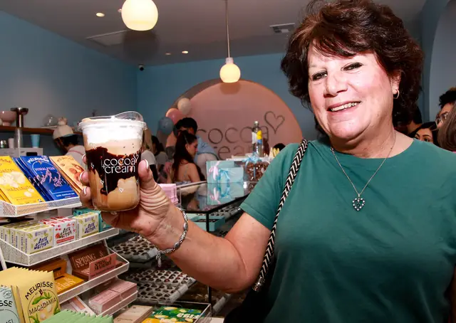 Guest with a Cocoa & Cream drink inside the shop