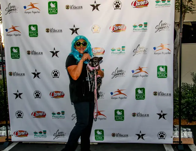 Costumed guest with a dog at the sponsor photo wall