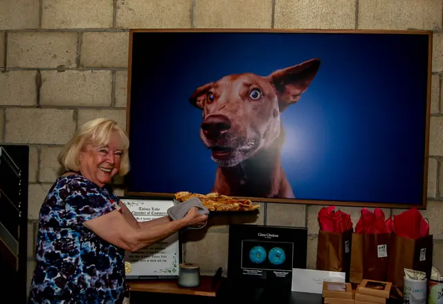 A guest beside a dog portrait in the Shuttermutt Photo studio