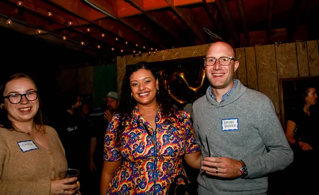 Members mingling under the string lights at the Sky Properties mixer