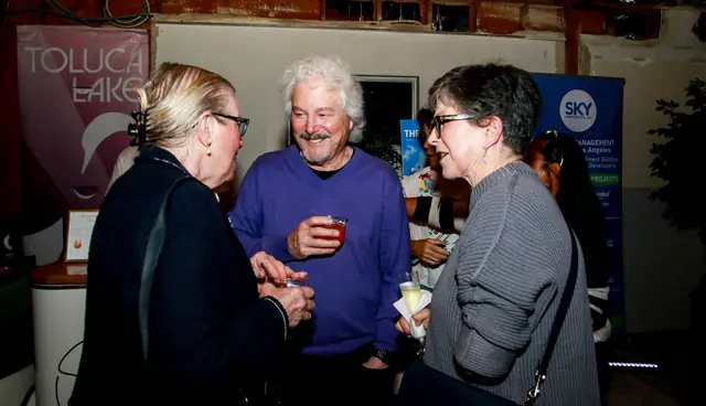 Guests chatting beside the Toluca Lake Chamber banner